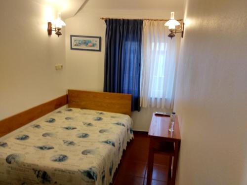 a small bedroom with a bed and a window at Rimavier Residence in Peniche