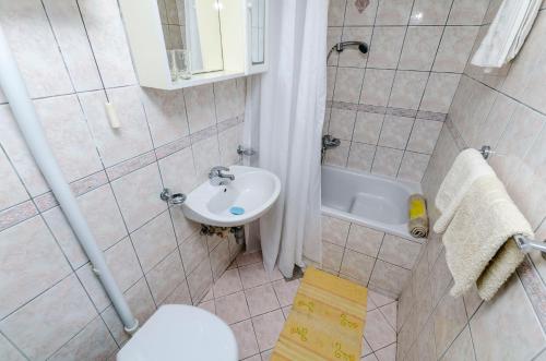 a bathroom with a sink and a toilet and a tub at Rooms Roza in Vrboska