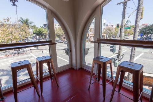 a group of stools in a room with windows at Broadlind Hotel in Long Beach