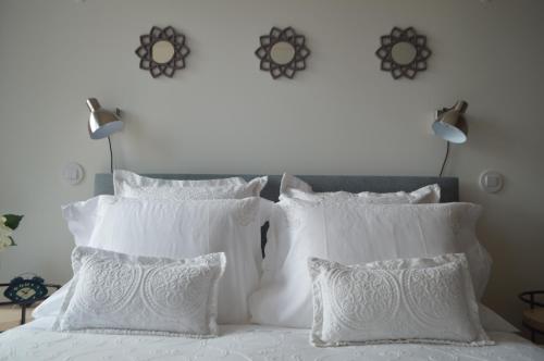 1 cama blanca con almohadas blancas y 2 lámparas en Camões by Trindade Sweet Home, en Oporto