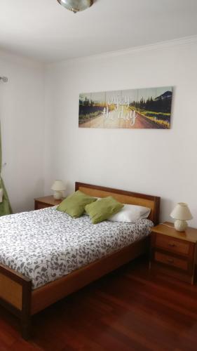 a bedroom with a bed with two tables and a picture on the wall at Ericeira Beach Haven in Ericeira