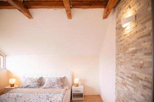 1 dormitorio con cama y pared de ladrillo en Apartments Nina, en Bled