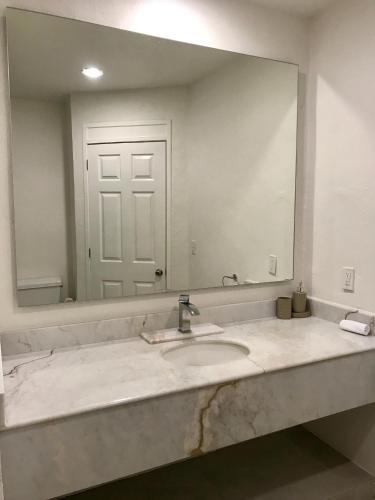 a bathroom with a sink and a large mirror at Villa 18 Con Playa 3 Recamaras dentro de Hotel en Ixtapa in Ixtapa