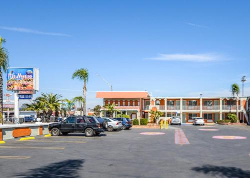 a parking lot with cars parked in front of a building at Aqua Venture Inn in Long Beach