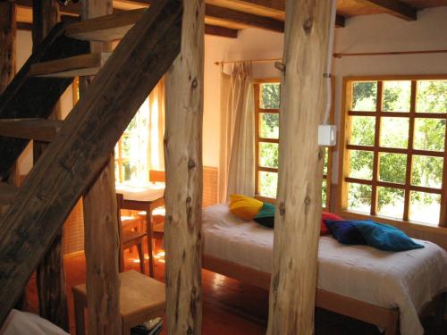 Habitación con 2 camas y 2 ventanas. en Remanso Andino, en Palena
