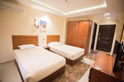 a hotel room with two beds and a table at Majorica Marina Hotel in El Alamein