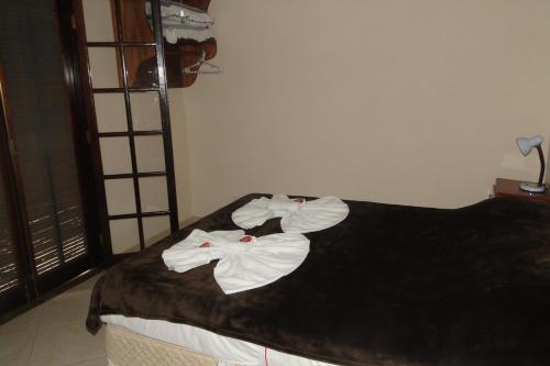 a bedroom with a bed with towels on it at Chácara Martinez in Conservatória