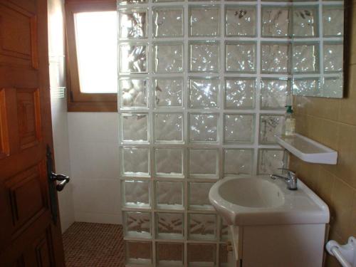 a bathroom with a sink and a glass block wall at Casa Ian in Moraira