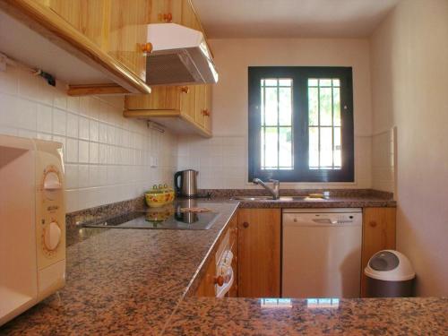 una cocina con fregadero y refrigerador en Bungalow La Joya, en Benitachell
