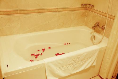 a bath tub with some red flowers in it at Khách sạn Công Đoàn Quảng Bá in Hanoi