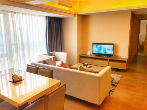 a living room with a couch and a television at Yuwa Serviced Residence in Foshan