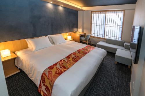 a hotel room with a large bed and a chair at Miru Kyoto Nishiki in Kyoto