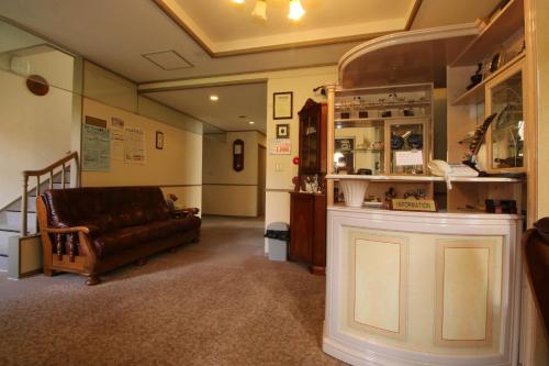 a living room with a leather couch in a room at Petit Resort Hotel Der Barte in Zao Onsen