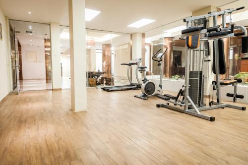 a gym with several treadmills and elliptical machines at Central Boutique Hotel in Vientiane