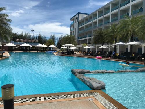 a large swimming pool in front of a hotel at Grand Blue Condominium by Mary in Mae Pim