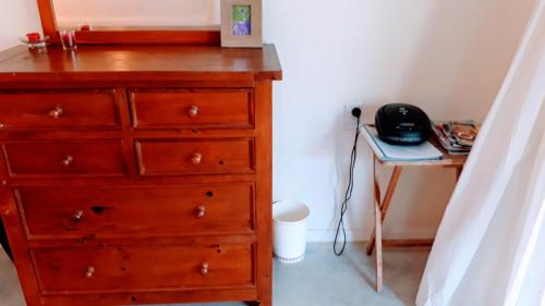 a bedroom with a dresser and a telephone next to a desk at Herons Reef Holiday Apartments in Rarotonga