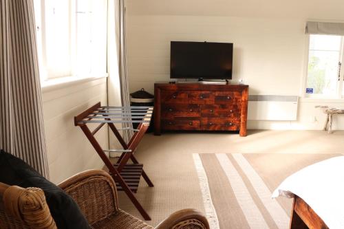 a living room with a television and a glass table at Historic Colenso Cottage in Napier
