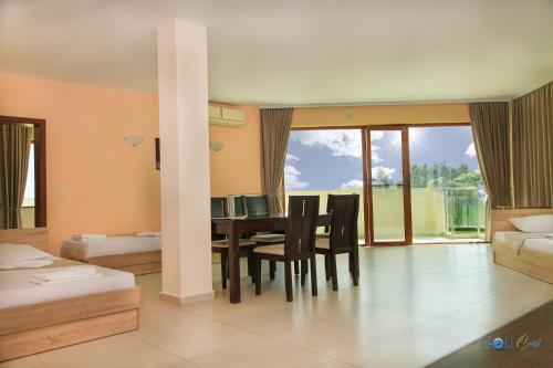 een slaapkamer met een tafel en stoelen en een eetkamer bij Aparthotel Golf Coast in Kavarna