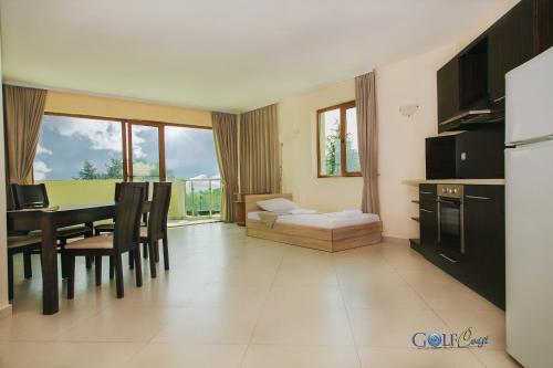 Aparthotel Golf Coast في كافارنا: غرفة معيشة مع طاولة وغرفة طعام