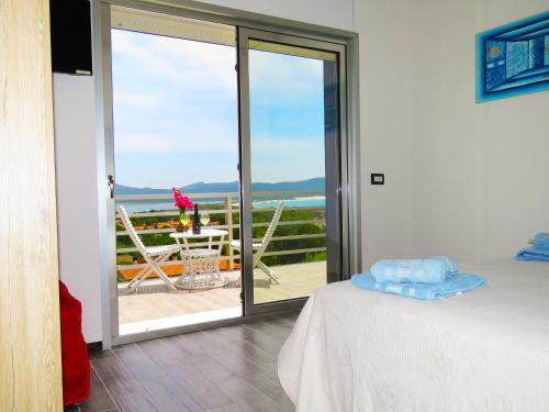 een kamer met een bed en een balkon met uitzicht bij Panohome in Porto Pino