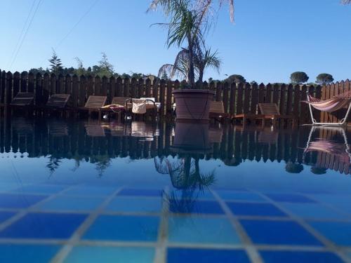 a pool of water with chairs and a fence at Il Castello in Piazza Armerina