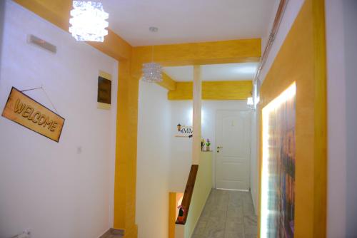 a hallway with yellow walls and a white door at Apartments MM in Nikšić