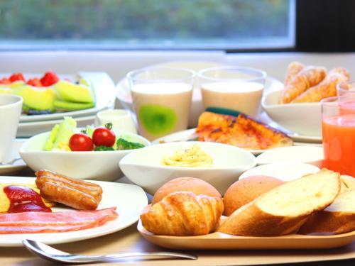 a table topped with plates of food and drinks at Sakaide Plaza Hotel in Sakaide
