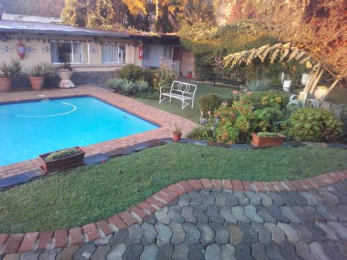 uma piscina no quintal de uma casa em Accoustix Backpackers Hostel em Joanesburgo