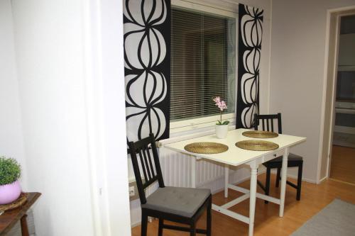 mesa y sillas en una habitación con ventana en RBA RentHouse Apartment 1, en Nedervetil