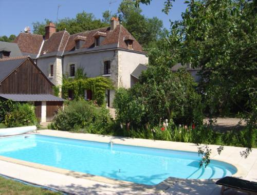 une grande piscine devant une maison dans l'établissement Chambre d'Hôtes Le Moulin des Landes, à Vernou-sur-Brenne