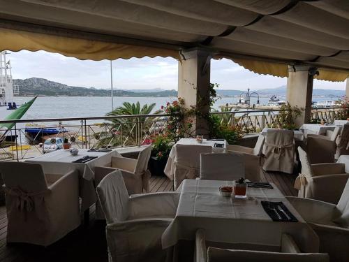 a dining room with tables, chairs and umbrellas at Excelsior in La Maddalena