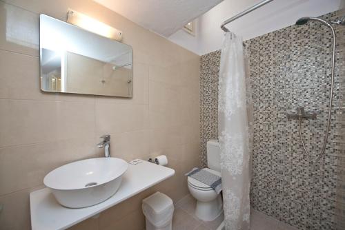 y baño con lavabo, aseo y ducha. en Karboni Hotel, en Mykonos ciudad