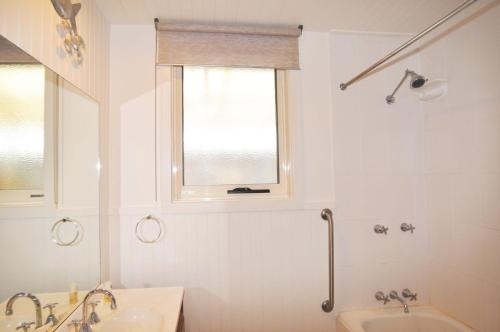 a bathroom with a tub and a sink and a window at 45 HALFORD - PET FRIENDLY in Inverloch