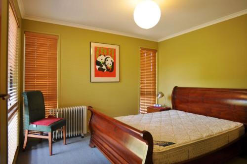 a bedroom with a bed and a chair at BEACHCROFT - INLET SIDE in Inverloch