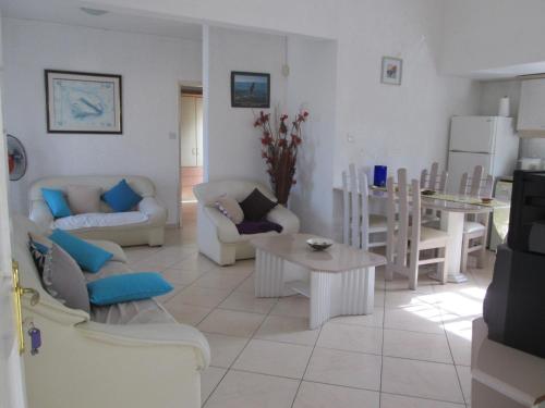 a living room with white furniture and a table at Grenadier A in Flic-en-Flac