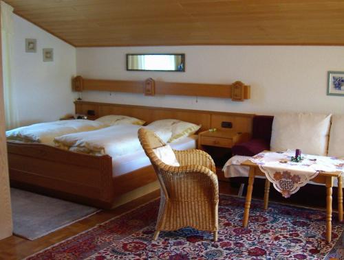 Un dormitorio con una cama y una mesa y sillas. en Appartementhaus Moser, en Bad Füssing