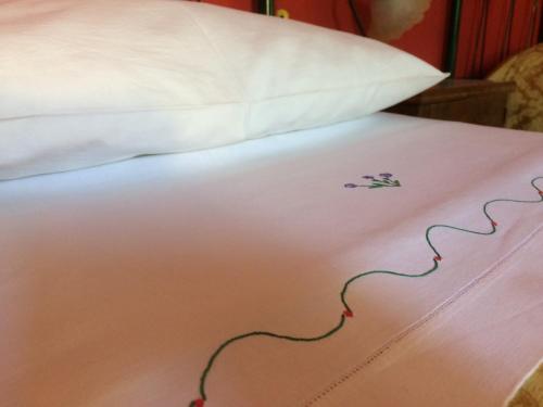 a bed with a white pillow and a flower on it at Affittacamere Varone in Montaquila