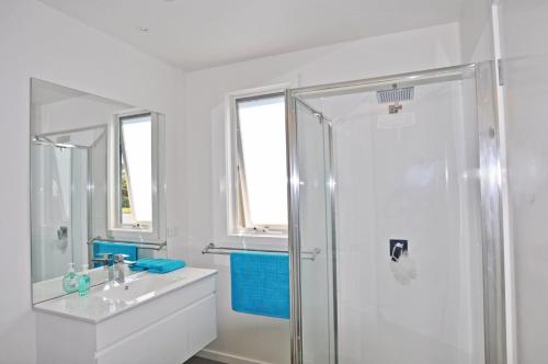 a white bathroom with a shower and a sink at SCARBOROUGH Serenity in Inverloch