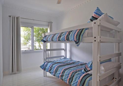 a bedroom with a bunk bed and a ladder at SEA WHISPERS - INLET SIDE in Inverloch