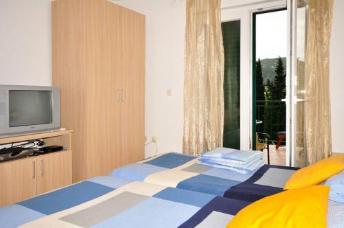 1 dormitorio con 1 cama, TV y ventana en Apartments Franic, en Ploče