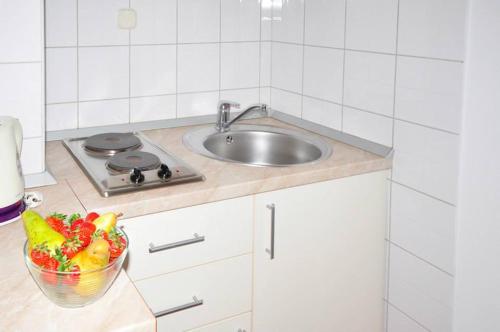 una cocina con fregadero y un bol de fruta en Apartments Franic, en Ploče