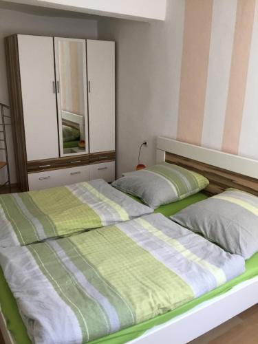 a bedroom with two beds with green and white sheets at Ferienwohnung Misch in Eschwege
