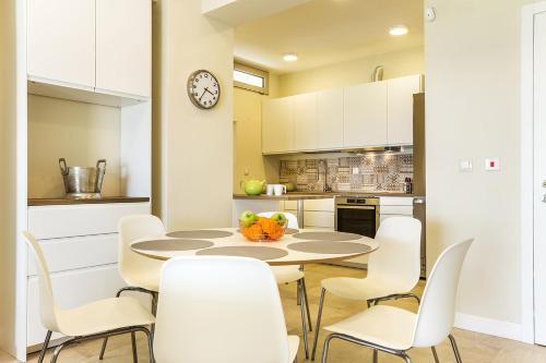 a kitchen with a table and white chairs at A&A Luxury Beach Villas in Nikiti
