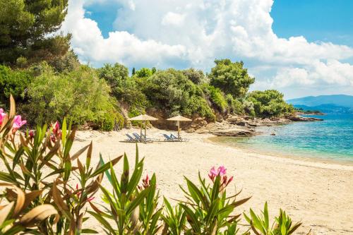 a beach with umbrellas and chairs and the ocean at A&A Luxury Beach Villas in Nikiti