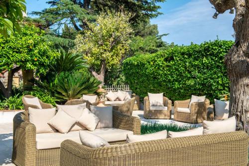 a group of wicker couches sitting in a yard at Best Western Premier Montfleuri in Sainte-Maxime