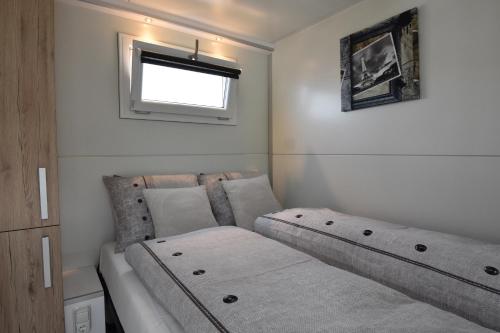 een kleine slaapkamer met een bed en een raam bij Cosy floating boatlodge, "Paris" in Maastricht
