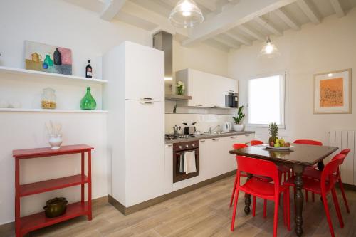 a kitchen with a table and red chairs in a room at Apartments Florence - Fiesolana Balcony in Florence