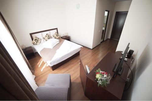 a bedroom with a white bed and a table with a table sidx sidx at Bungalouri La Mare*** Saturn in Mangalia