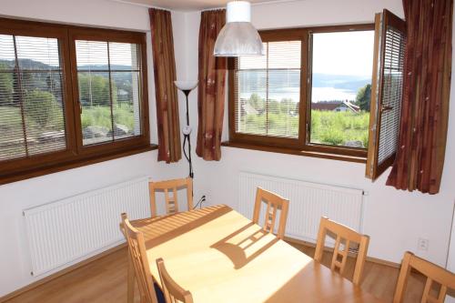 a dining room with a table and chairs and windows at Villa Park Lipno-Lipno-In in Lipno nad Vltavou