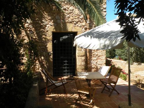 a patio with a table and chairs and an umbrella at the ancient sicilian house near zingaro reserve Scopello in Scopello